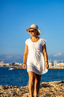 Portrait Shooting für die werbung, eine frau im weissen kleid mit hut am strand ; fotografiert von fotoboss.ch